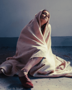 Mujer envuelta enuna sabana pensando, triste sin energia,